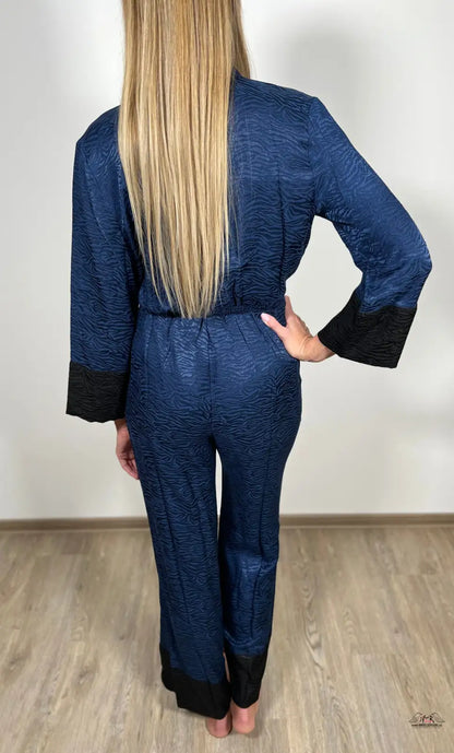 Žena z pohledu zezadu ve modrém overalu od Victoria’s Secret