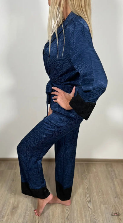 Žena v modrých sametových pyžamech a černých kalhotách od Victoria’s Secret
