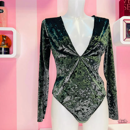 Mannequin in a green and black bodysuit showcasing Zelené semišové body s odvážným výstřihem